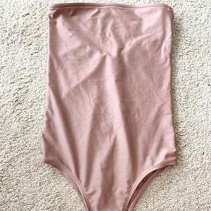 Body na-kd strl xs - Rosa baddräkt/ body från na-kd utan axelband. Aldrig använd. Strl XS men passar även S. 