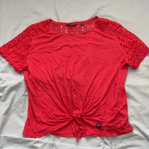 Superdry t-shirt  - Söt t-shirt med blommig spets och knytbar framtill. Bra skick, storlek L. Köpare står för frakt och betalas via Swish✨