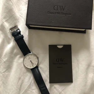 DANIEL WELLINGTON KLOCKA - DW klocka med svart läderband. Medföljer låda och manual. Köpt på NK i Stockholm för cirka 3 år sedan. Modellen heter CLASSIC SHEFFILED