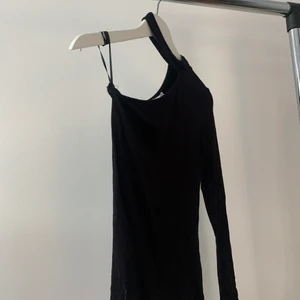 Enarmad svart tröja  - Något figursydd svart tunna tröja med en arm och en ”chocker” 