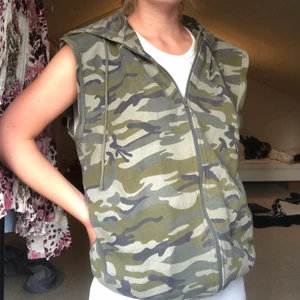 Hoodie med avklippta ärmar - Hoodie med avklippta ärmar i camouflage mönster! Storlek L, på mig är den snyggt oversized. Superbra skick !