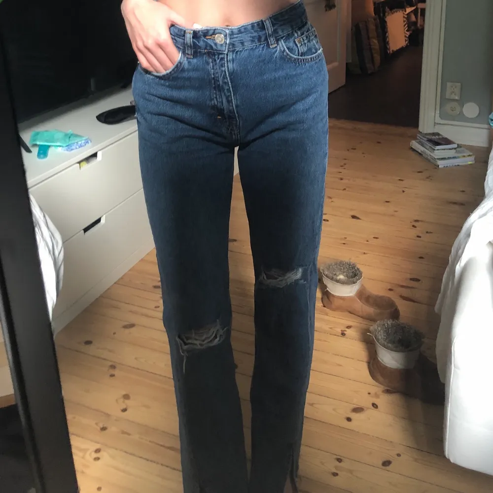 Ett par snygga blåa jeans från pull & bear med hål på knäna. Storlek 36 och super bekväma. Jag är 175 cm lång och brukar ha 34-36 i jeans. Dom har även en slits!. Jeans & Byxor.