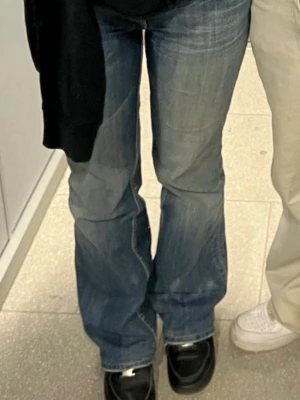 Miss me  bootcut jeans - säljer ett par blå jeans från Miss Me med bootcut passform och låg midja. Jeansen har slitna detaljer, paljetter och camouflage-tyg på bakfickorna . storlek w30 l30 