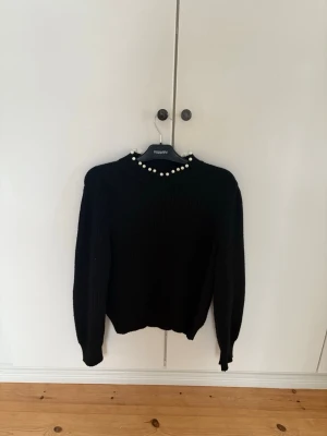 Svart stickad tröja med pärlor - Säljer en svart stickad tröja från Vero Moda. 