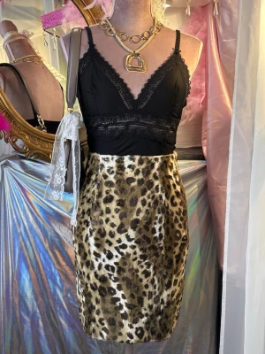 Leopardmönstrad kortkjol i fuskpäls - Snygg figurnära vintagekjol i jättefin och mjuk leopard fuskpäls.  • Storlek: XS/S (Märkt 38, men liten i storlek). • Mått: Midja ca 33 cm, längd ca 49 cm. • Skick: Bra vintageskick, men har visst slitage/fransiga kanter vid midjan (se bilder). 
