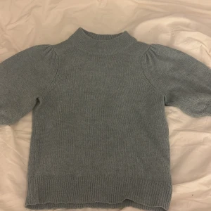 Ljusblå trekvärtsarmad tröja - Mysig ljusblå trekvärtsarmad stickad tröja från Jacqueline de Yong med hög krage(turtle neck)och puffiga lite ärmar. Tröjan har ribbade muddar vid ärmslut och nederkant, vilket ger en snygg och modern look. Perfekt för kyliga dagar! 