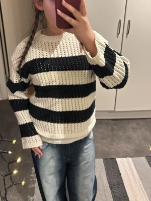 Randig stickad tröja från Cubus - Säljer en stickad tröja från Cubus i storlek 146/152. Tröjan har breda svarta och vita ränder, rund halsringning och långärmad modell. Materialet är grovstickat och ger en luftig känsla. Perfekt för dig som gillar en avslappnad och trendig stil.