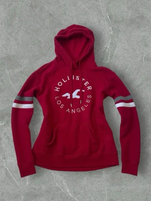 Hollister Red Hoodie with White/Grey Details – Size 34 - Hollister red hoodie with white and grey details. Comfortable and casual style, great for everyday wear. Size 34. Great condition.  #hollister #hoodie #redhoodie #casualwear #streetwear #size34 #vinted