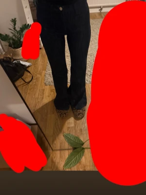 Mörkblå bootcut jeans - Säljer ett par mörkblå jeans med bootcut passform och hög midja. Jeansen har klassiska fickor fram och bak, och är tillverkade i ett stadigt denimtyg. Perfekta för dig som gillar en tidlös look med lite extra vidd vid benslutet.