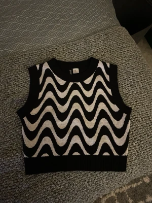 Svartvit stickad magtröja  - Magtröja som är stickad och har mönster på fram sidan. Tröjan har använda fåtal gånger är fortfarande i god skick. 
