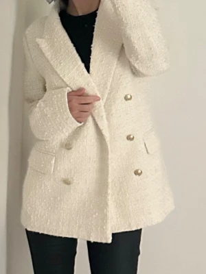 Vit kavaj med guldknappar - Säljer en snygg vit kavaj i strukturerat tyg med dubbelknäppning och guldiga knappar. Storlek S helt oanvänd men har ej prislappen på.