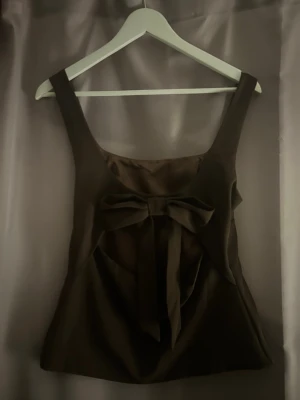 Brun topp med rosett bak🤎 - Jättefin brun topp med rosett bak och öppen rygg🤎 Tjockt och bra material som ger fin passform!! Aldrig använd 🌟 