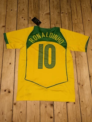 Ronaldinho tröja  - Säljer min retro Brasilien tröja med #10 ”Ronaldinho” på ryggen. Tröjan är helt ny och oanvänd. Bara hör av er om ni har några frågor.