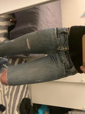 Blå bootcut jeans vintage storlek s-xs low waist  - Skit snygga blåa boot cut vintage  jeans som är super low waist från ett märke som heter ”trend” säljer för jag har växt ut dem och blivit för lång. Super low waist och snyggt slitet med hål och detaljer. Och läder fickor med snygga detaljer och nitar. Sytt på egna nya knappar som är glittriga. Dem har haft 2 hål men som jag sytt igen och funkar nu bra, de syns inte när man har på dem. Dem sitter som s/xs. Mått: midja rakt över 41 cm Innerbenslängd 82 cm Mått längst ner på benet tvärs över 23 cm
