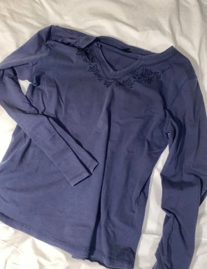ZE-ZE långärmad med brodyr - Supersöt mörkblå långärmad från märket ZE-ZE. Den har en supercool urringning med både brodyr och en unik form av v-ringning. Den sitter löst på mig som är XS/S, men det tycker jag kan vara snyggt. Passar till alla säsonger och tilld de flesta outfits. 