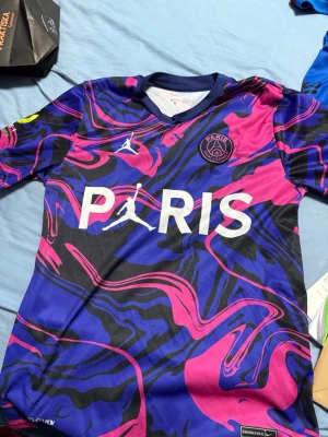 Psg t shirt  - Bilderna visar en PSG fotbollströja med Mbappé och nummer 7, men inga skor finns med.