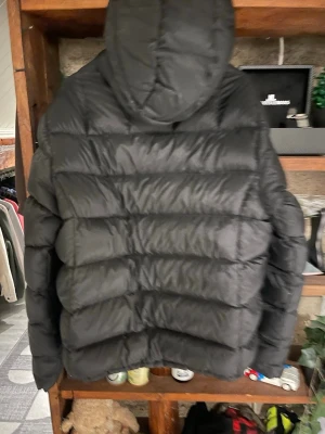 Svart pufferjacka med huva - Säljer en svart pufferjacka med huva och dragkedja framtill. Mckinley jacka