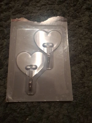 Hjärt krokar - Bilden visar två hjärtformade krokar i plastförpackning, tror de är som klistermärken bakom hjärtna.