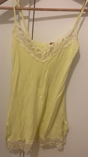 Gul linnetopp med spets  - Säljer en ljusgul linnetopp från Tessie i storlek S/M. 