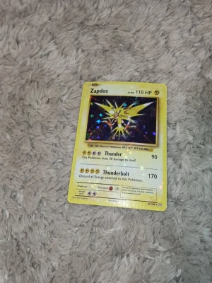 Zapdos Holo 2016 - Bilderna visar ett Pokémonkort med Zapdos, men ingen väst finns med. Kan därför inte ge någon beskrivning av en väst.