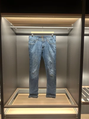 Lee jeans - Säljer ett par blå Lee Luke jeans i klassisk femficksmodell. Jeansen har en snygg tapered passform och normal midja. Materialet är slitstarkt denim i bomull och de har Lee-logga på bakfickan. Perfekt för dig som gillar stilrena och bekväma jeans. Storleken är W30 och L32. Det är bara att höra av sig vid frågor eller funderingar 