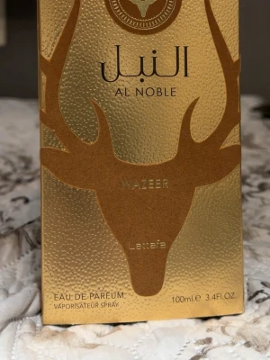 Lattafa Al Noble Wazeer Parfym 100ml - Al Noble Wazeer från Lattafa är en Eau de Parfum i en unik flaska med guldiga detaljer. Volym: 100ml. Perfekt för dig som vill sticka ut med en exklusiv och trendig doft på hyllan. Väldigt sofistikerad doft! 