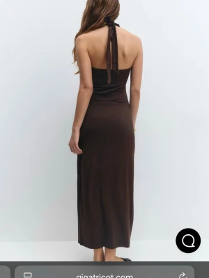 Brun långklänning med halterneck - Säljer en snygg brun långklänning från Gina Tricot med halterneck och knyt i nacken. Aldrig använd!