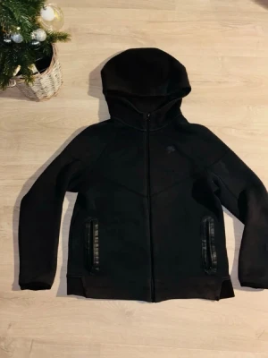 Svart Nike tech  - Svart Nike tech från Nike storlek 170. Varm och skön inuti perfekt nu för vintern