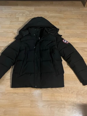Canada Goose Wyndham Svart - Säljer nu denna canada goose wyndham modellen med röd logga. 10/10 skick för att jag köpte den nyss och den inte passade så den är oanvänd. Pälsen finns också om du vill ha med det.  Pris kan diskuteras vid snabb affär. Vid frågor hör av er 🤗
