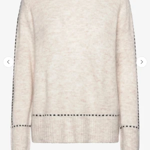 Ljusbeige stickad tröja med svarta detaljer - Mysig ljusbeige stickad tröja med svarta prickdetaljer längs muddar och nederkant. Tröjan är nästan oanvänd. 