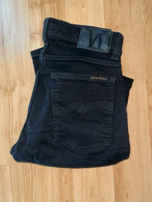 Nudie Jeans - Säljer ett par svarta skinny jeans från Nudie Jeans i modellen Tight Terry. Midja 34cm, längd 104cm. JAG SKICKAR EJ FLER BILDER NÄR JAG BÄR JEANSEN! för bättre inblick i passformen rekommenderar jag att googla på modellnamnet. För storleksguide kolla måtten noggrant då jeansen alltid kan vara uppsydda heller krympta och jag ej tar emot returer :) s5,4