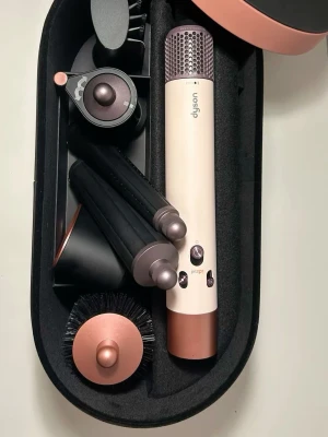 Dyson Airwrap multistyler i koppar - Multistyler från Dyson i färgen koppar och rosa. Setet innehåller flera stylingtillbehör som borste, locktillbehör och fönmunstycke. Perfekt för att skapa olika frisyrer med ett enda verktyg. Kommer i en snygg förvaringsbox.