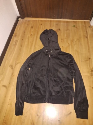 Svart hoodie med dragkedja - Svart hoodie i mjukt material med dragkedja framtill och huva med snörning. Perfekt för en avslappnad stil och enkel att matcha med andra plagg. På grund av att jag har klippt bort alla lappar så vet jag tyvärr inte vad det är för storlek eller var den kommer ifrån men skulle uppskatta att den är ungefär storlek xs - s🥰🫶🏻 TRÖJAN ÄR INTE SMUTSIG, DET ÄR MIN KAMERA DET ÄR FEL PÅ!
