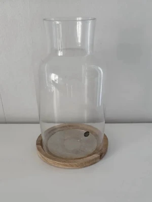 Sagaform ljushållare/ljuslykta - 22,5×14cm - En elegant och stilren ljushållare/ljuslykta från Sagaform, använd ett fåtal gånger. Ger ett mycket fint och harmoniskt ljus och passar lika bra i vardagsrum som på matbord eller uteplats. Några mindre tecken på användning finns på glaset, glasskivan på träfoten har lossnat (se bilder), i övrigt i gott och fint skick! Perfekt för dig som vill ha en snygg designljuslykta till ett bättre pris. Mått: 22,5×14cm. Nypris 649kr! FÖRST TILL KVARN!