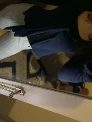 Mörkblå omlottopp med knyt - Snygg mörkblå omlottopp med knyt framtill. Toppen har långa ärmar och en djupare v-ringning. Perfekt att matcha med både jeans och kjol. Storlek: XS. Har lite färg på slutet av ärmen som ni ser på bilden, men inget som man märker direkt. 