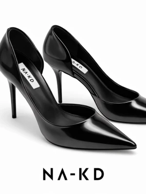 Svarta pumps med spetsig tå från NA-KD - Stilrena svarta pumps från NA-KD i glansigt syntetmaterial. Skorna har spetsig tå och hög klack som ger en elegant siluett. Perfekta för dig som vill ha en klassisk och trendig look.
