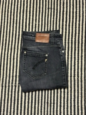 Mörkgrå jeans från Dondup - Snygga mörkgrå jeans från Dondup med klassisk femficksdesign och läderpatch bak i midjan. Jeansen har raka ben och diskreta slitningar för en cool look. Perfekta till både sneakers och boots.