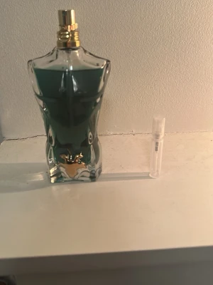 Le beau parfym från Jean Paul Gaultier - Ikonisk parfymflaska formad som en manlig torso från Jean Paul Gaultier. Flaskan är genomskinlig med blågrön vätska och gulddetaljer vid halsen. Perfekt för dig som vill ha en unik och klassisk doft i badrumshyllan.