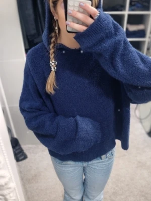 💙Mjuk stickad hoodie i marinblått💙 - Supermjuk och mysig stickad hoodie i en djup marinblå färg. Tröjan har en lätt croppad passform med ribbad nederkant och ärmar som ger en snygg och avslappnad look. Den fluffiga texturen gör den extra bekväm och perfekt för både vardag och mysigare tillfällen. Huvan är mjuk och faller fint, vilket ger en trendig men fortfarande enkel stil. Lätt att matcha med jeans, mjukisbyxor eller kjol.💙🥰