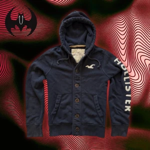 Vintage marine blå kofta Hollister - Extremt sällsynt mörkblå kofta med tryck och broderat vitt Hollister-tryck på bröstet och höger armen | extremt svårt att hitta och limiterad | size M / L | längd: 67 cm Axelbredd: 46cm Armlängd: 72cm 