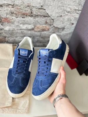 Valentino Rockrunner blå sneakers - Snygga Valentino Rockrunner sneakers i marinblå mocka med vita detaljer och platt sula. Skorna har snörning och coola nitar på hälen för extra edge. Perfekt för dig som vill sticka ut med ett lyxigt streetwear vibe.