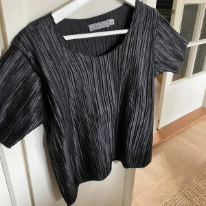 Svart plisserad blus från Schutz - Ribbad glansig lite festligare t-shirt 