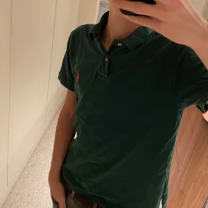 Mörkgrön Polo Ralph Lauren t-shirt - Säljer denna tvär sköna Ralph lauren piké som passar till alla tillfällen. Pikén är i bra skick och sitter bra på modellen . Modellen är 180 och väger ca 62 kg. För mer frågor eller behov av bilder är det bara att skriva till mig!