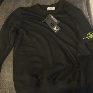 Svart sweatshirt från Stone Island - Svart långärmad sweatshirt från Stone Island med påse. Jag har inte använt den till något tillfälle men testat den och märke att den va för liten på mig.därför försöker jag sälja min stone Island tröja för personer med en helt ren stil 🔥🔥