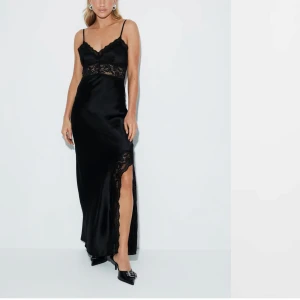 Spetsklänning satin gina Tricot  -  Svart långklänning i satin med spetsdetaljer och smala axelband. Klänningen har en slits och öppen rygg. Från Gina Tricot, slutsåld online. Oanvänd med prislapp kvar. Skickas eller kan hämtas i Partille.