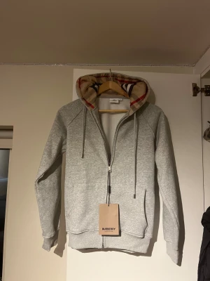 Burberry Hoodie - Säljer nu denna snygga burberry hoodie på grund av att den inte passar. Helt ny aldrig använd. Storlek S-M. Skulle säga att den passar bättre för folk med storlek S 