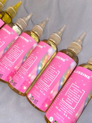 Glossine hårolja med rosa etikett - Hårolja från Glossine i genomskinliga plastflaskor med rosa etikett och regnbågsmönster. Innehåller 150 ml, är sulfat- och silikonfri. Flaskan har en smal spets för enkel applicering. Perfekt för att fräscha upp huden under dagen.