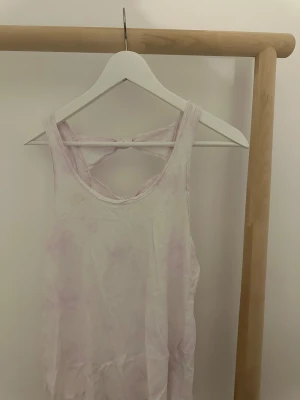 Ljuslila linnetopp från Abercrombie & Fitch - Säljer en ljuslila linnetopp från Abercrombie & Fitch i storlek S. Toppen har ett snyggt knyt-detalj i ryggen med två rosetter och är ärmlös. Materialet är mjuk bomull och färgen är svagt lila.