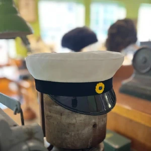 Klassisk Studentmössa Uppsala modellen svart st 52-63 - Klassisk studentmössa med vit ovandel i bomull, svart band och blank svart skärm. Framtill sitter en klassisk kokard. Insidan har det klassiska foder i blått och gult. Finns storlekar från 52 – 63. Limiterat lager