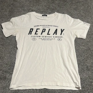 Vit t-shirt från Replay med tryck - Vit t-shirt från Replay med svart tryck framtill som har texten 'Custom Service Garage'. Klassisk rund halsringning och korta ärmar. Skön och lätt i bomull, perfekt till jeans eller shorts. Pris kan diskuteras!